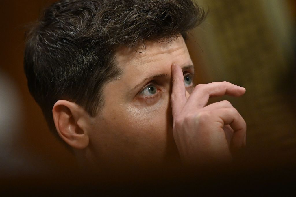 Image may contain Sam Altman Head Person Adult Face Photography Portrait Body Part Finger Hand and Contact Lens